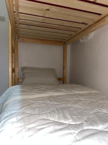 a white bed in a room with a wooden ceiling at Adar guest house in Agadir