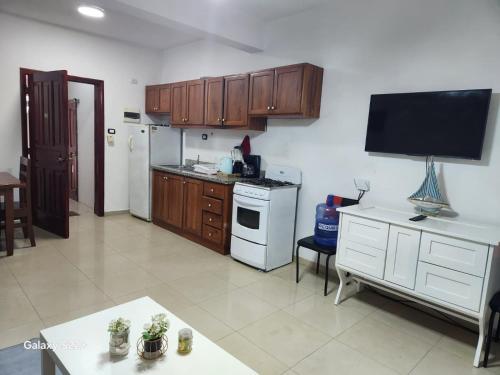 a kitchen with wooden cabinets and a white refrigerator at Sol Dominicus apart 5 Solo Adultos in La Laguna