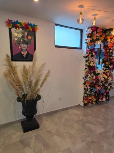 a room with a plant in a vase and a wall with flowers at Le 46 Appart Hotel Entre Paris Disneyland Parc Asterix Navette in Villiers-sur-Marne