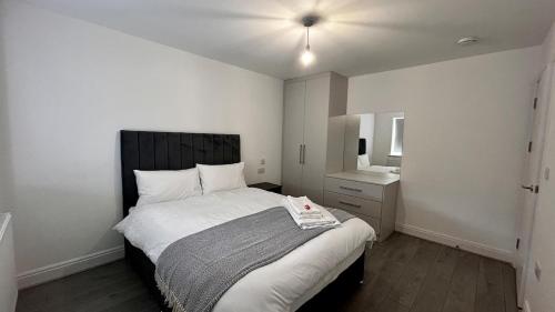a bedroom with a large bed and a sink at Spacious 4 Bedroom House for 8 Guests Ideal for Families and Contractors, WIFI and Free Parking in Aldershot