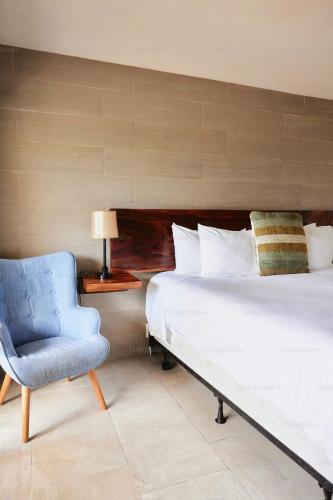 a bedroom with a bed and a blue chair at Hotel Nysha Delhi in New Delhi