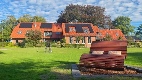 a large house with an orange roof in a yard at Meine Schule Sehlingen, Dein Hideaway für ZWEI, Land- oder Radurlaub in der Lüneburger Heide, Nordpfade, Workation mit Sauna, Ruhe & Erholung oder Niedersachsen Städte wie Hamburg, Hannover, Bremen und Verden entdecken in Kirchlinteln