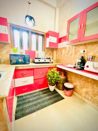 a kitchen with red cabinets and potted plants in it at Rudra Homestay Varanasi in Varanasi