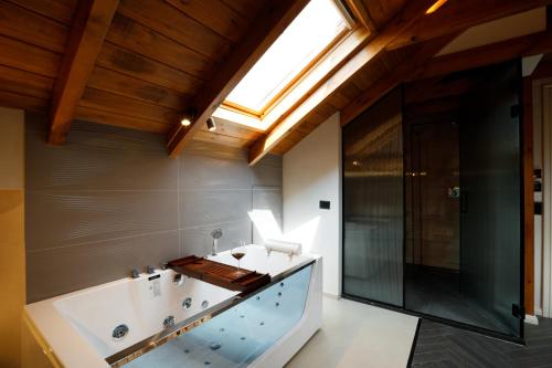 a bathroom with a large tub and a skylight at Nostalgia Boutique Hotel in Gjirokastër