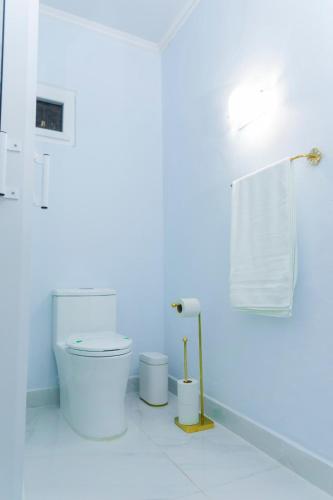 a white bathroom with a toilet and a towel at Cozy apartment monica in San Pedro Sula