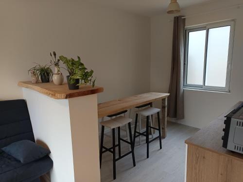 a kitchen with a table and stools in a room at Chez Colette in Aucey-la-Plaine