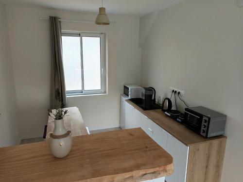 a kitchen with a counter with a microwave and a window at Chez Colette in Aucey-la-Plaine