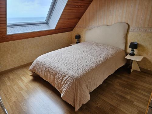 a bedroom with a bed and a window at Vauville Sunset in Vauville