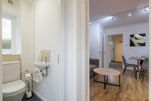 a bathroom with a toilet and a sink and a table at 4 BDR I sleeps 8 I Wi-FI I Free Parking I Central in CBG