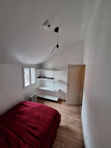a white bedroom with a red bed and a cabinet at Résidence Alma in Valenciennes