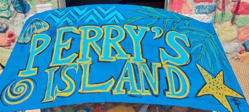 a blue umbrella with a sign that reads happy rentals island at New Perry's Island in Nuweiba‘ el Muzeinah