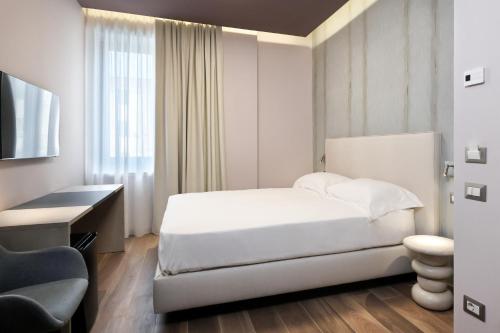 a bedroom with a bed and a desk and a chair at Primo Piano Rooms in Aversa