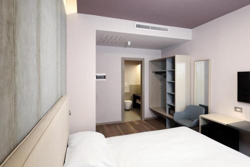 a bedroom with a bed and a desk and a television at Primo Piano Rooms in Aversa