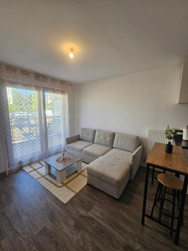 a living room with a couch and a table at Le Nid Urbain in Villiers-le-Bel