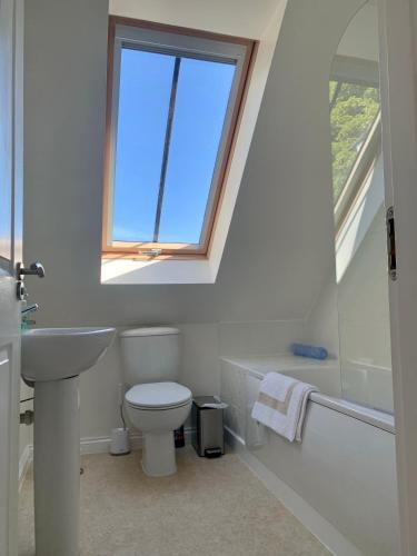 a bathroom with a toilet and a sink and a window at May Cottage in Anstruther