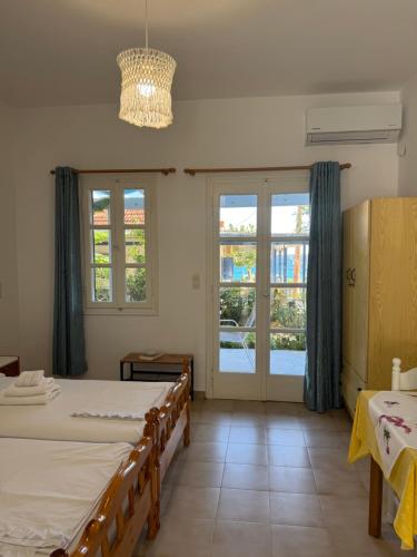 a bedroom with two beds and a chandelier at Jenny Apartments in Karlovasi