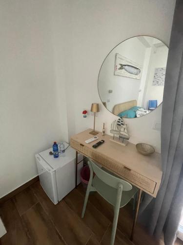 a room with a desk with a mirror and a bed at Cortile San Luigi in Capo dʼOrlando