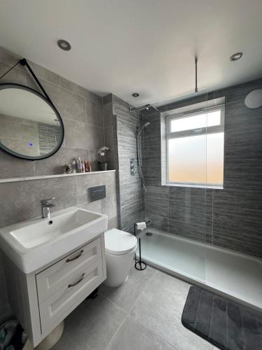 a bathroom with a sink and a toilet and a mirror at Seaside Getaway - Roebuck Cottage in Reighton