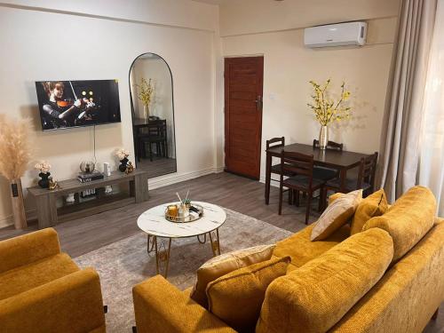 a living room with a couch and a table at Skimbo's Apartment in Lusaka