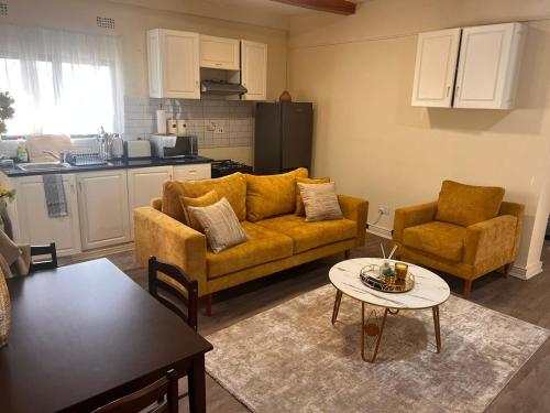 a living room with a couch and two chairs and a table at Skimbo's Apartment in Lusaka