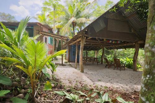 a building with chairs and a table in front of it at Nosara Samara, 2 BR, Jungle View, Fiber-Optic wifi in Nicoya