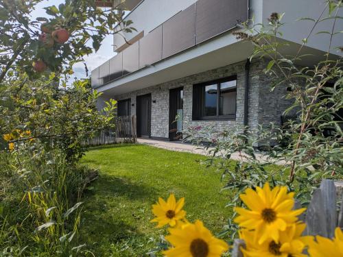 a garden with yellow flowers in front of a house at Ferienwohnung Bergzauber in Sankt Jakob in Haus
