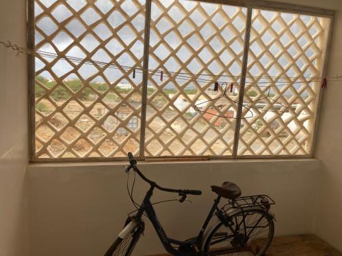 a bike parked in a room with a window at Prédio IFH Maio in Vila do Maio