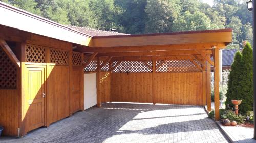 a wooden pavilion with a yellow door on a garage at Lauras Ferienwohnung - Ihr Wohlfühlort in der Südweststeiermark in Eibiswald