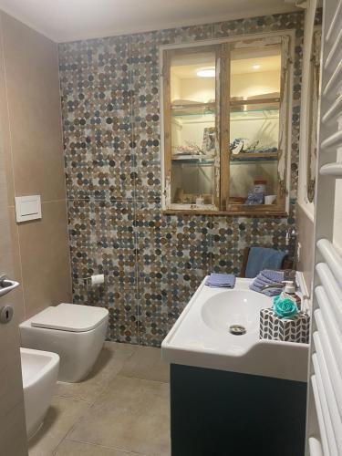 a bathroom with a sink and a toilet and a mirror at La Capanna 1857 in Peccioli