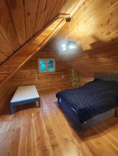 a bedroom with a bed and a bench in a attic at Chata Podzawale in Bircza