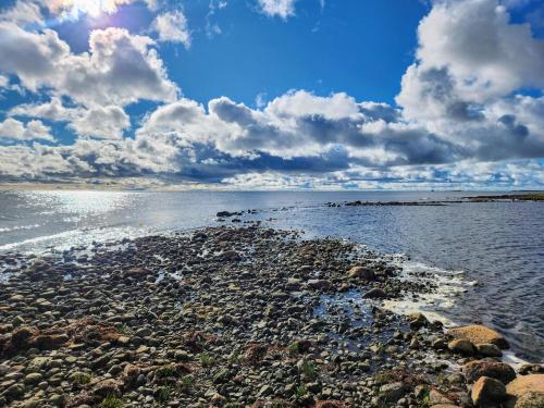 a beach with rocks in the water under a cloudy sky at 5 person holiday home in HALTORP-By Traum in Halltorp