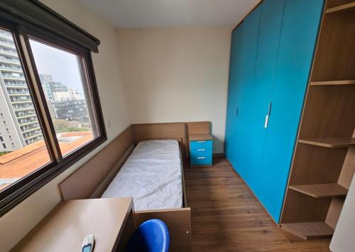 a small room with a bed and a window at Ed Plaza Viena Apto 3 Quartos Vista Mar in Florianópolis