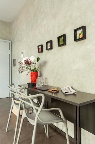 a table with two chairs and a vase of flowers on a wall at San Babila Suite in Milan