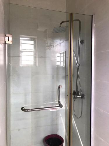 a shower with a glass door in a bathroom at Nin Lux suites in Lekki