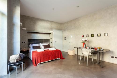 a bedroom with a bed and a table and chairs at San Babila Suite in Milan