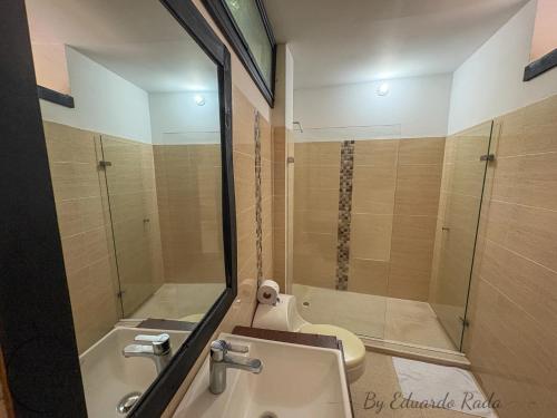 a bathroom with a shower and a sink and a toilet at Hostal Antawara Tayrona in El Zaino