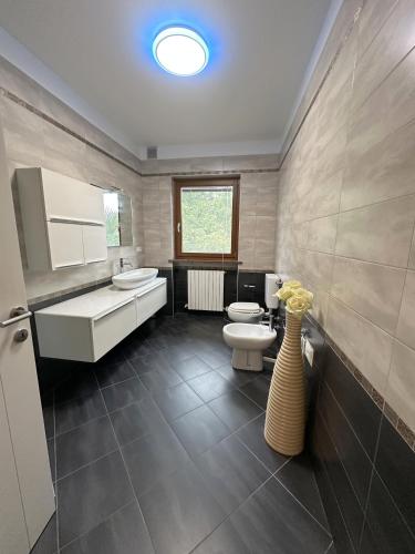 a bathroom with a sink and a toilet and a window at Ciconi Apartment in Gorizia