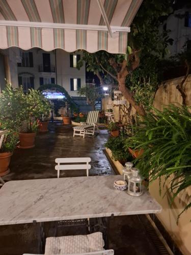 a patio with a table and chairs and plants at Nel Giardino di Carla in Rapallo