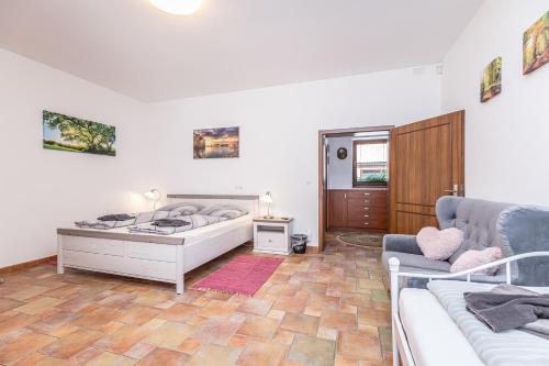 a bedroom with a bed and a couch at Penzion Šejby in Horní Stropnice