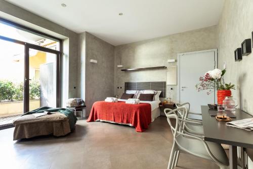 a bedroom with a bed and a table and chairs at San Babila Suite in Milan