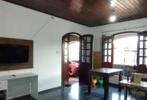 a living room with a tv and a table at Casa com 2 quartos in Ananindeua