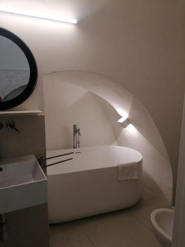a bathroom with a white tub and a sink at Allegra's Guest House in Ostuni