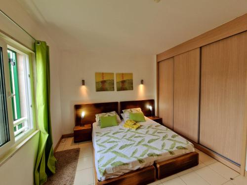 a bedroom with a large bed with green pillows at Stay, laugh, repeat! in Prainha