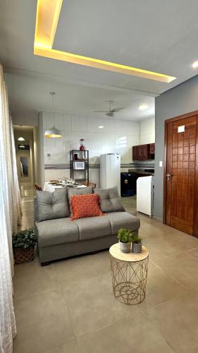 a living room with a couch and a kitchen at Comfortable house in Pedreira in Belém