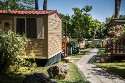 a tiny house in a yard with a pathway at hu I Pini village in Fiano Romano
