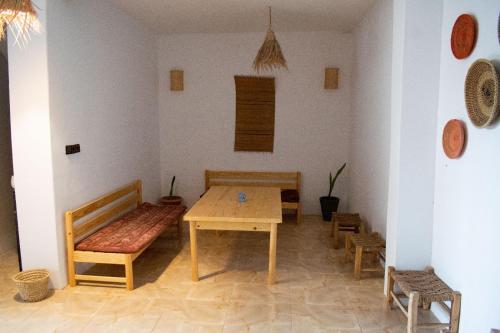 a table and benches in a room with a table and chairs at Eco Bay Surf Camp in Aourir