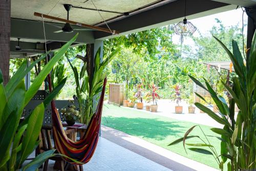 a patio with a hammock and some plants at Chiang Ron in Chiang Mai