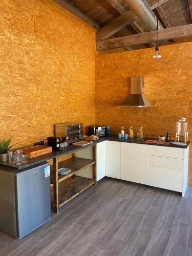 a large kitchen with white cabinets and a yellow wall at El Roble Glamping - Cabaña Container - Pet Friendly in Lagunilla