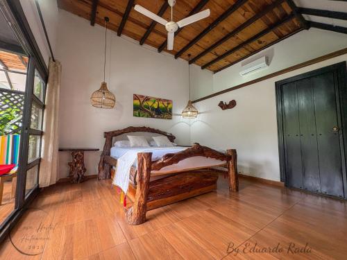 a bedroom with a bed and a wooden floor at Hostal Antawara Tayrona in El Zaino