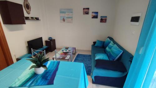 a living room with a blue table and a couch at Home Sweet Home Skala Fourkas in Skála Foúrkas